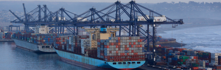 Panorámica de terminal con grúas y contenedores, acento sutil de la bandera de Chile
